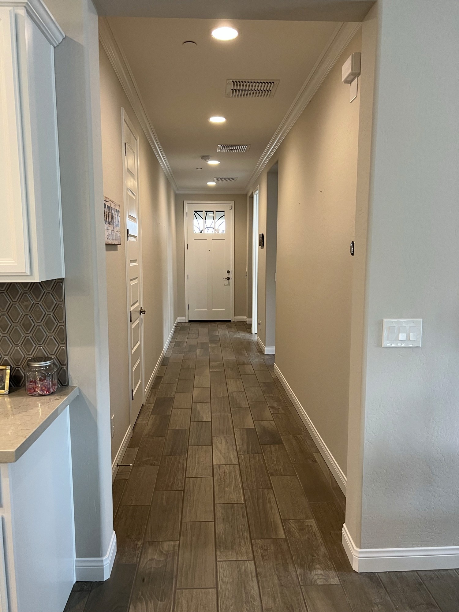 Long hallway with crown molding and baseboard trim